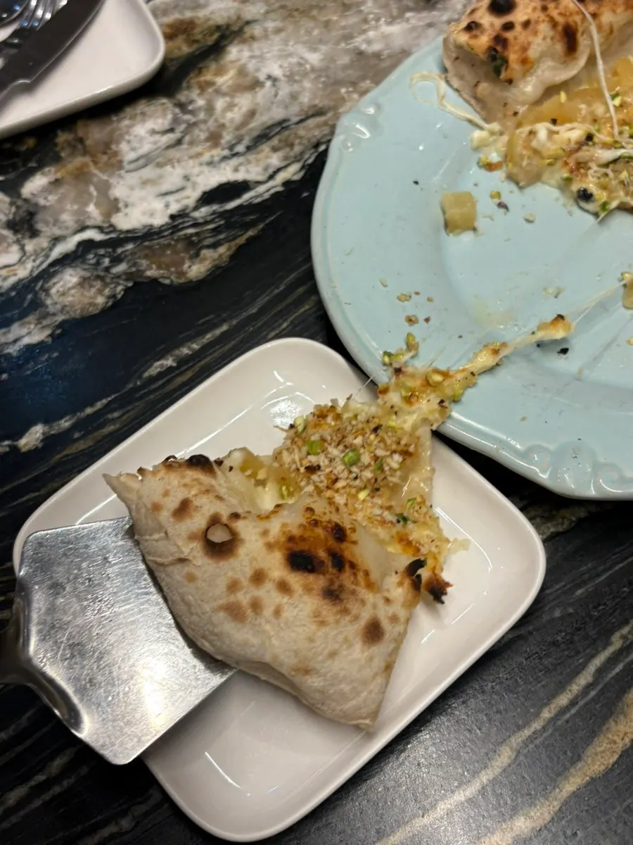 Slice of gorgonzola pizza topped with apple