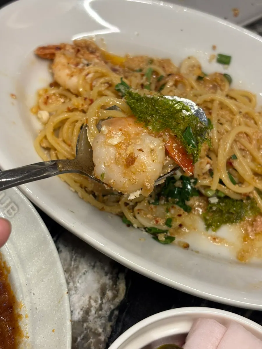 Oil pasta topped with shrimp and green sauce