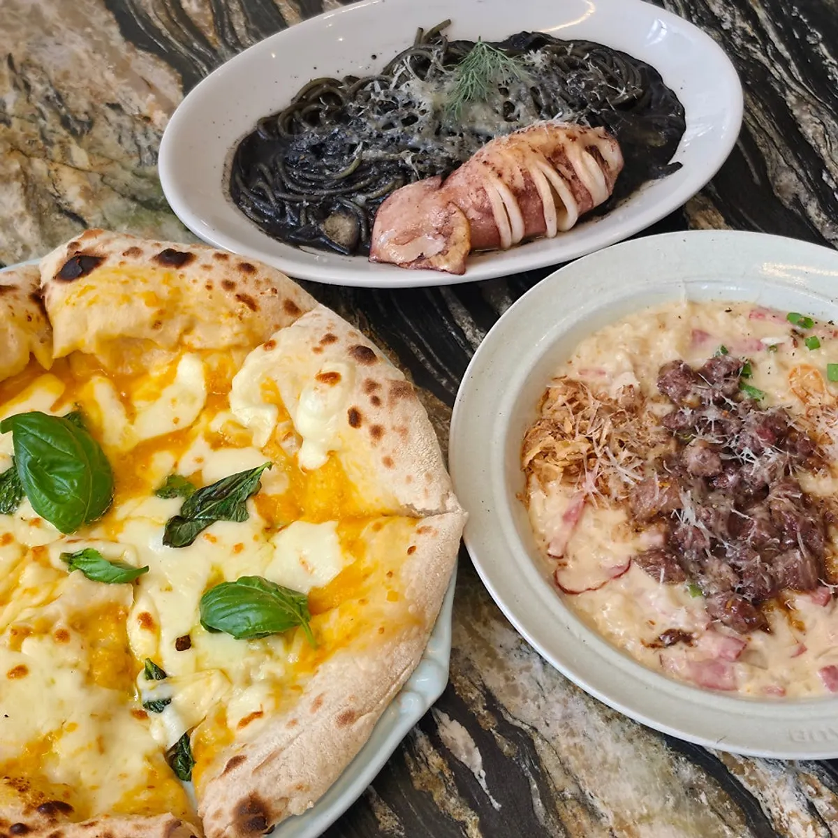 Table set with pizza, pasta, and risotto together