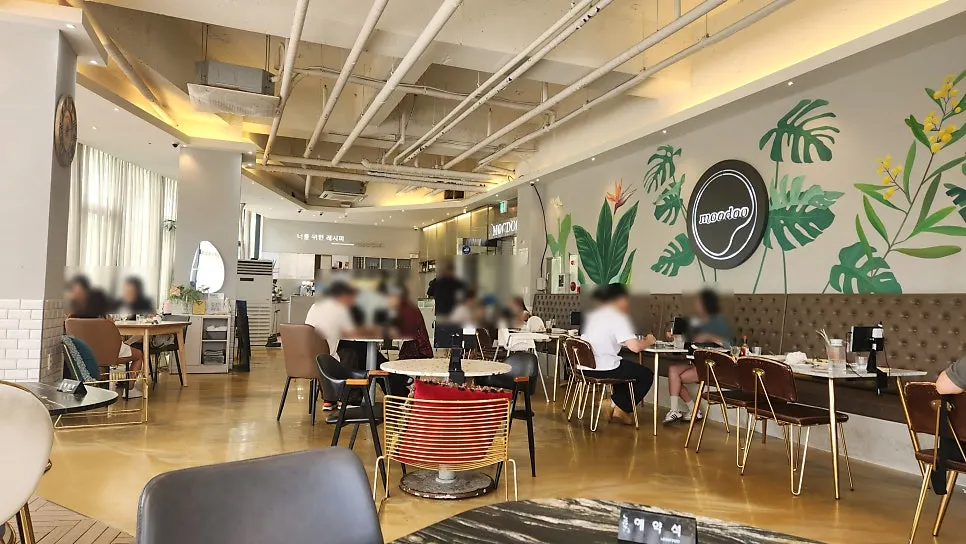 Dining hall seating with floor-to-ceiling windows, curtains, and soft lighting