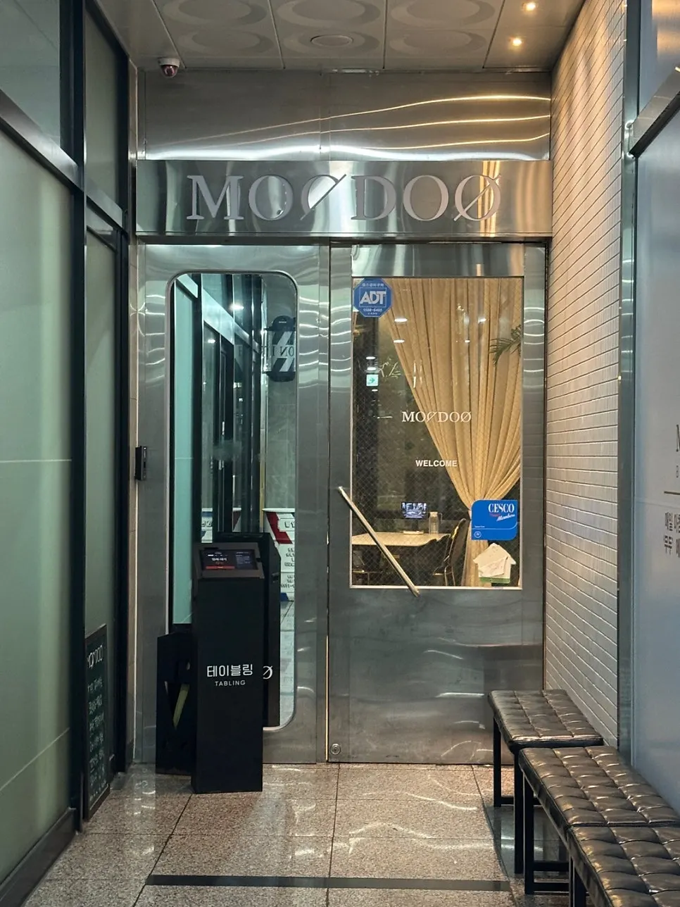 2nd floor restaurant exterior with tall windows and curtains visible
