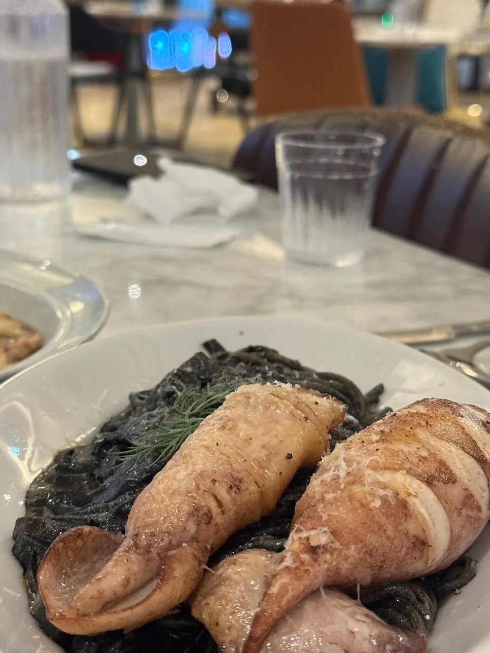 Squid ink pasta topped with a whole squid