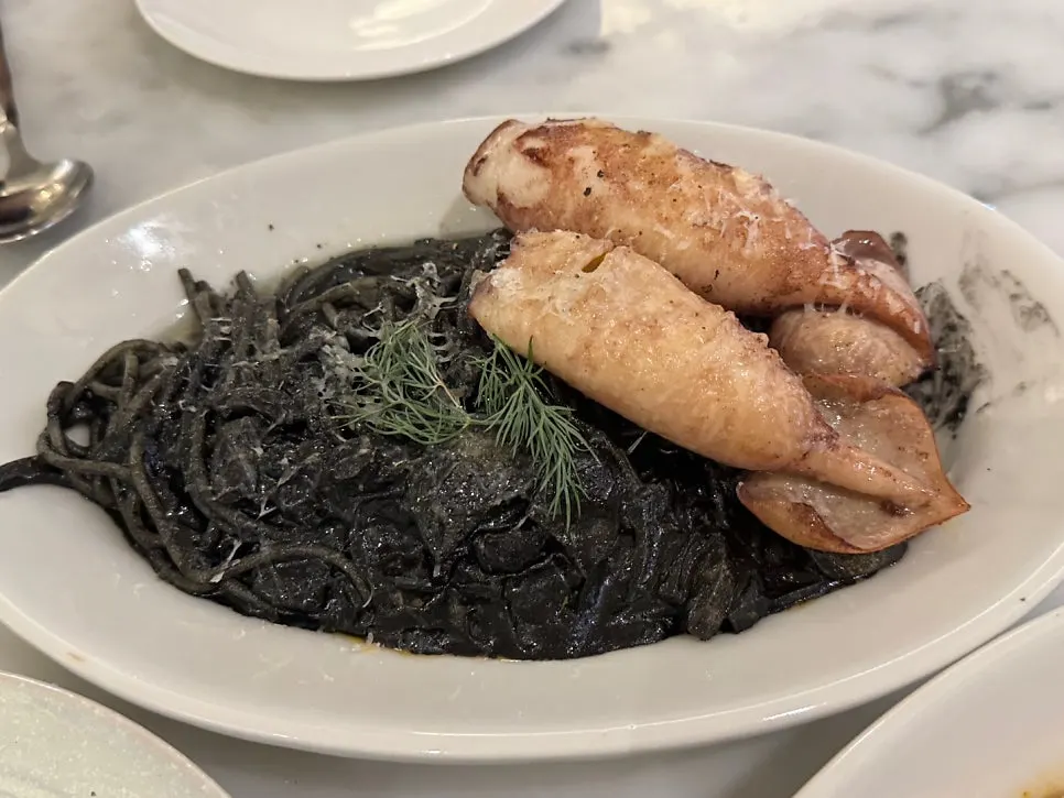 Close-up of squid ink pasta noodles and diced onion