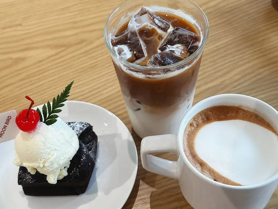 Café latte, vanilla bean latte, and real brownie ice cream set out on the table