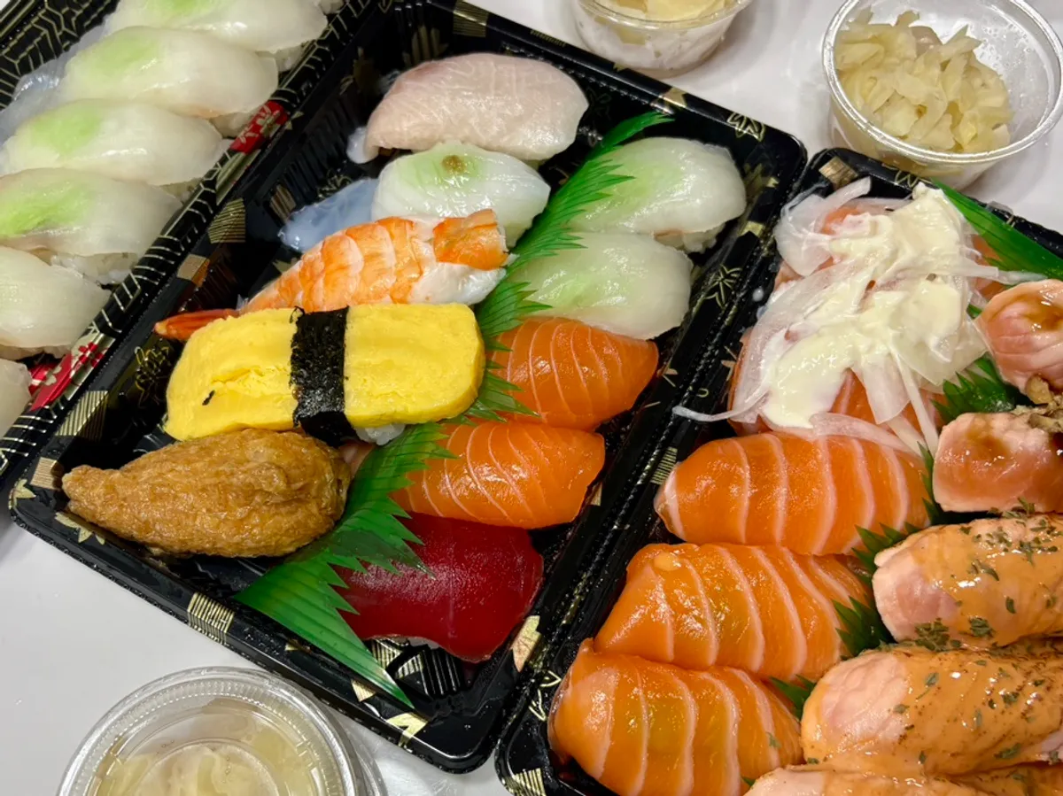 Three sushi sets laid out after takeout