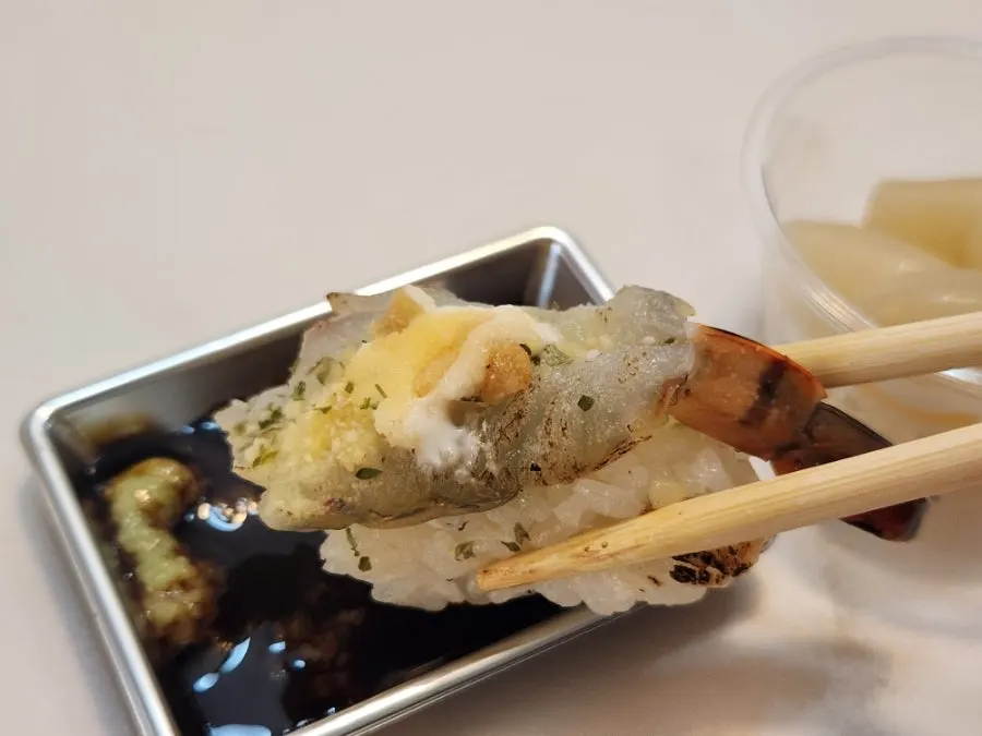 A thick piece of sushi picked up by hand