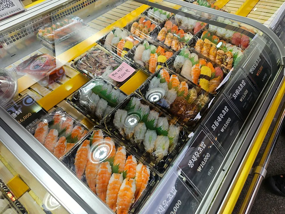 Menu board listing prices for mixed shrimp sushi and Moraenae sushi