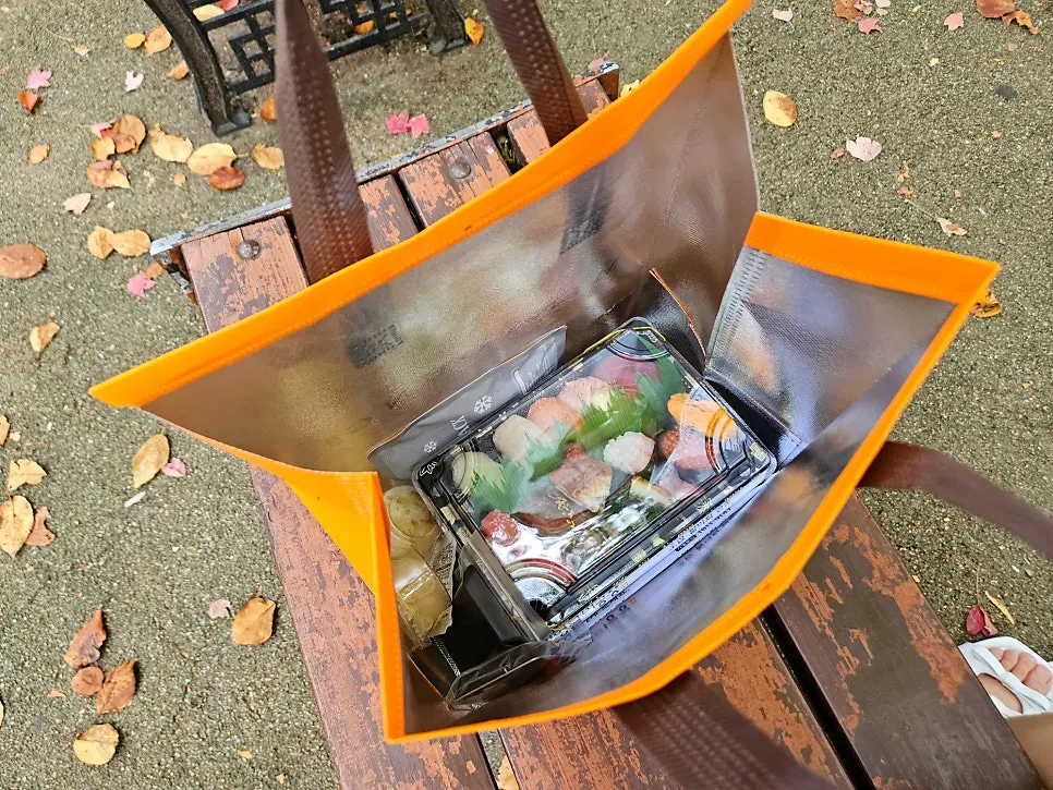 Packed sushi laid out on a picnic mat at Incheon Grand Park