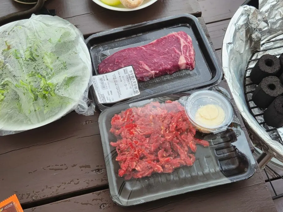Meat and side dishes being prepared for the pension barbecue
