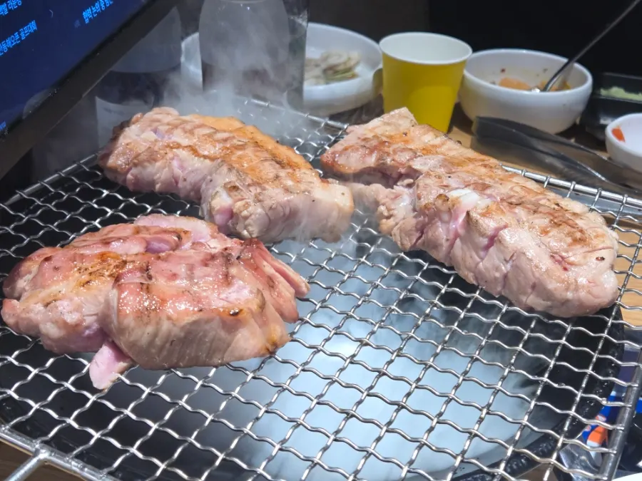 Pre-grilled meat being sliced on a cutting board