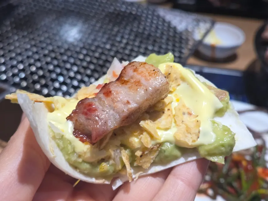 Taco wrap with tortilla, guacamole, and pork belly