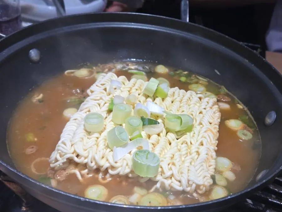 Pot of ramyeon being cooked with a pack of hanwoo bone broth