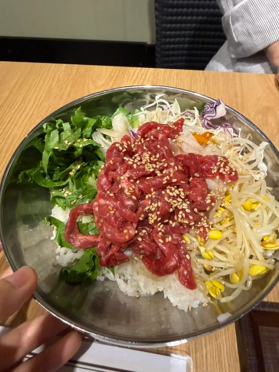 Yukhoe bibimbap topped generously with vegetables and raw beef