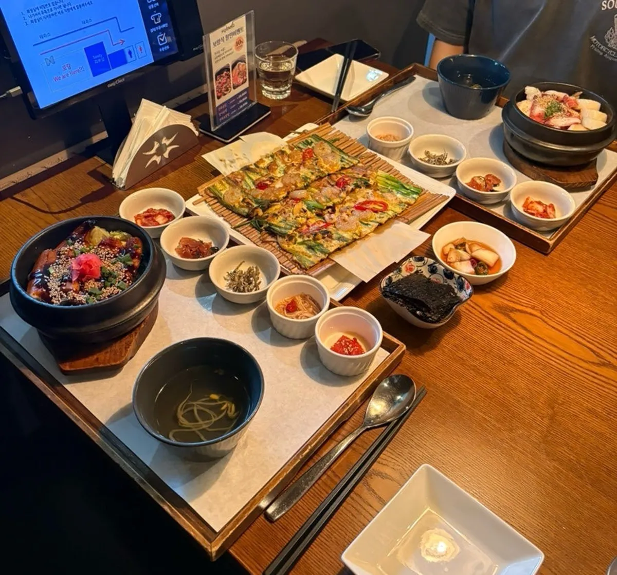 Table spread with two pot rice dishes, side dishes, and soup