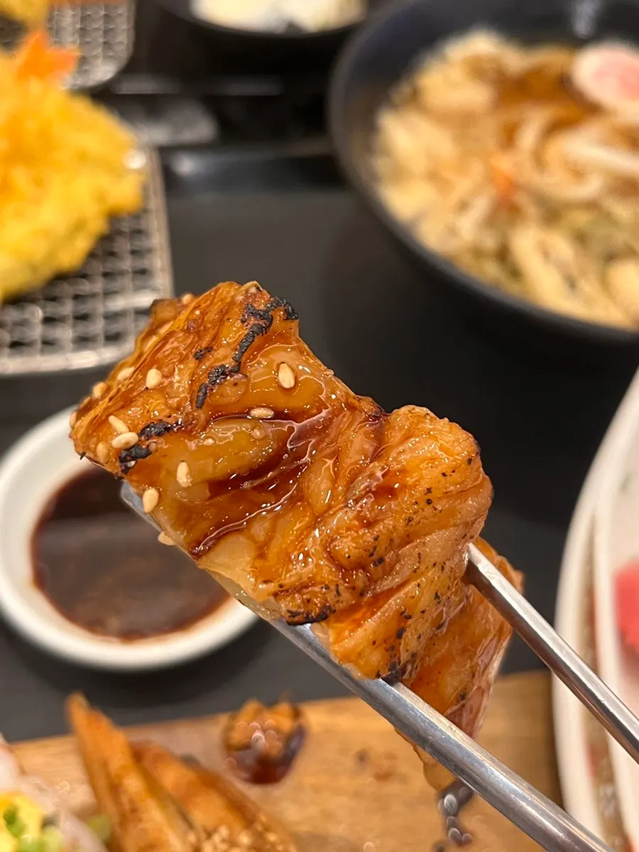 A piece of sushi picked up with chopsticks