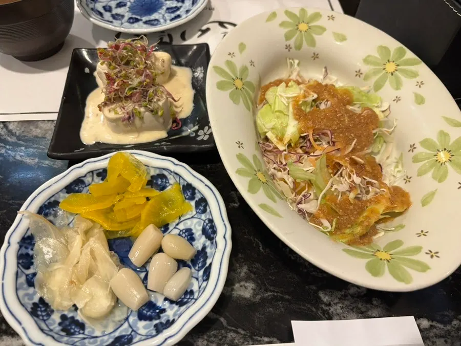 Pre-meal spread of salad, soft tofu, soup, pickled shallots, ginger, and pickled radish