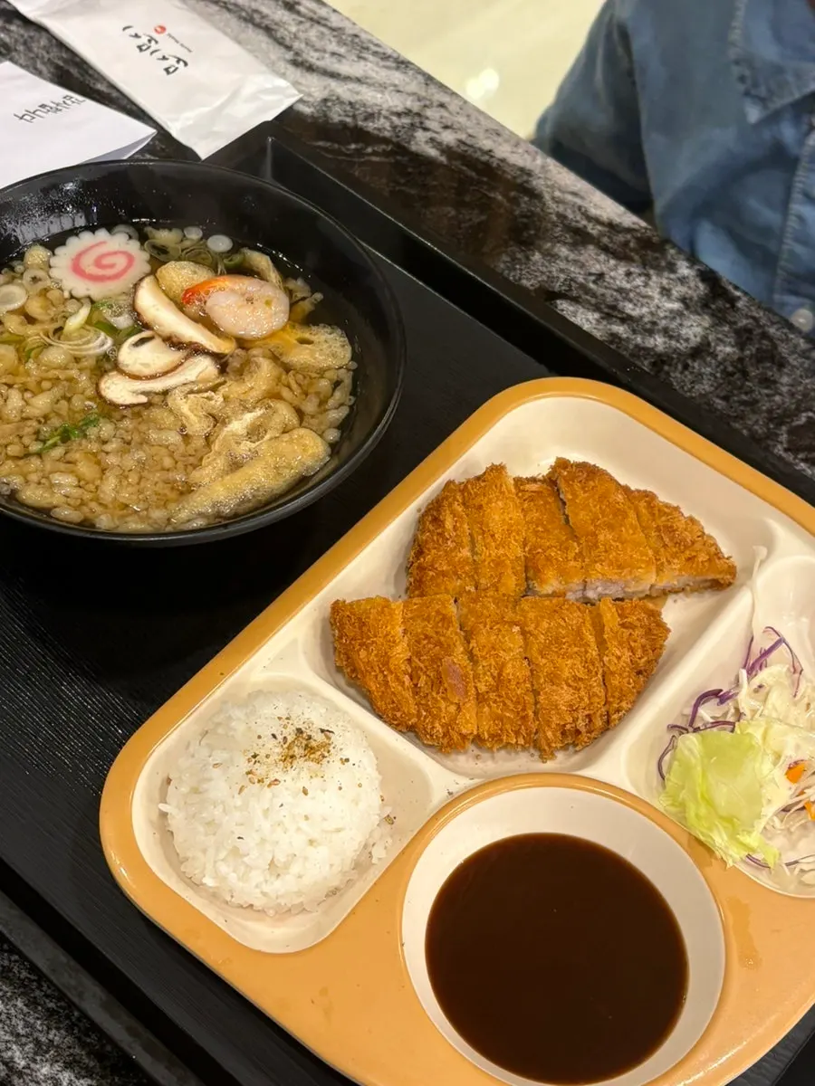 초밥 세트 두 개와 어린이 돈까스, 우동이 놓인 테이블