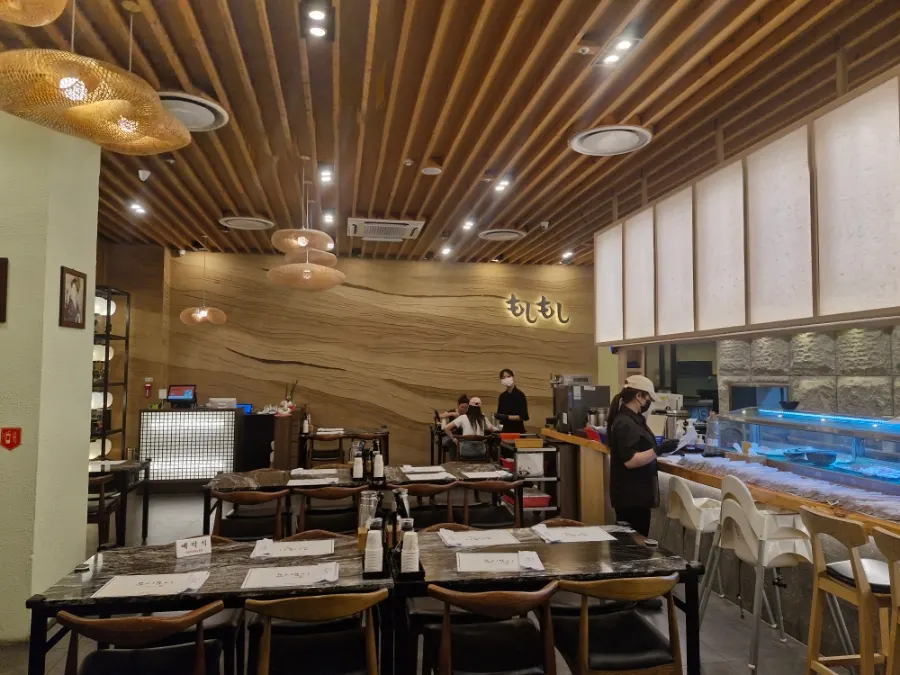 Interior of Moshi Moshi Sushi Gwangbok with counter seating and group tables