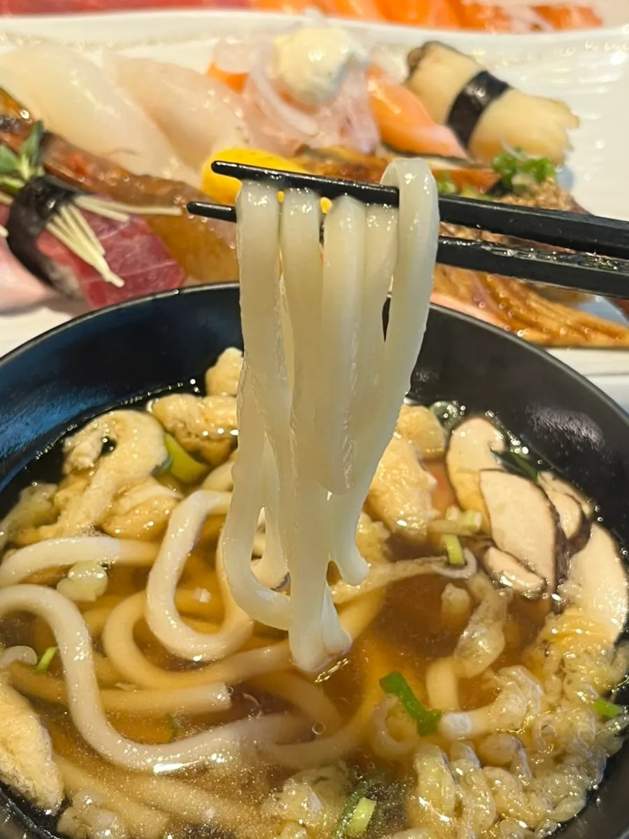 Complimentary udon topped with fried tofu and shiitake mushrooms