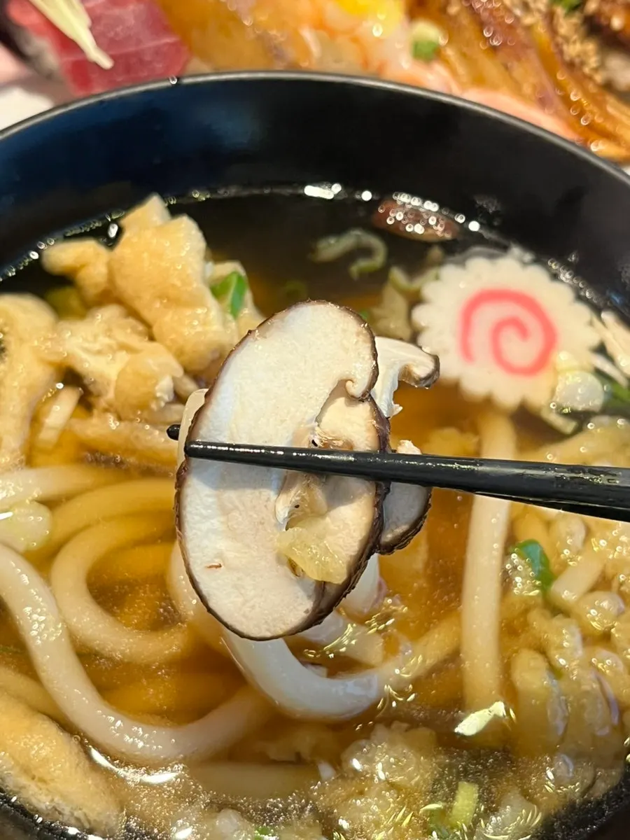 Udon broth served alongside sushi