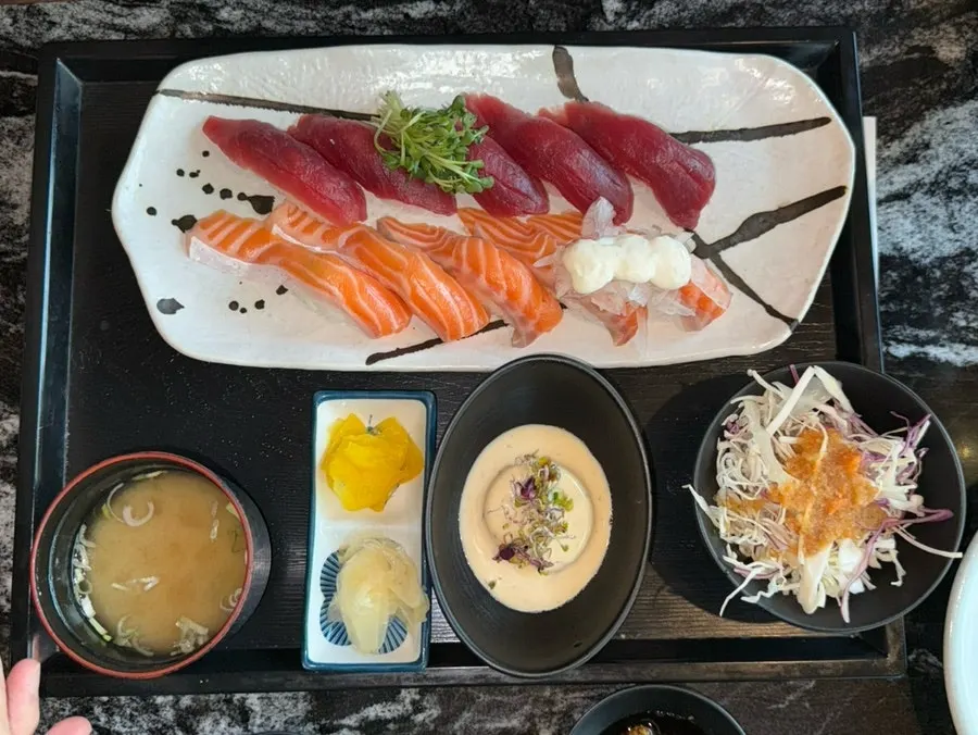 Plate of sushi topped with thick slices of sashimi