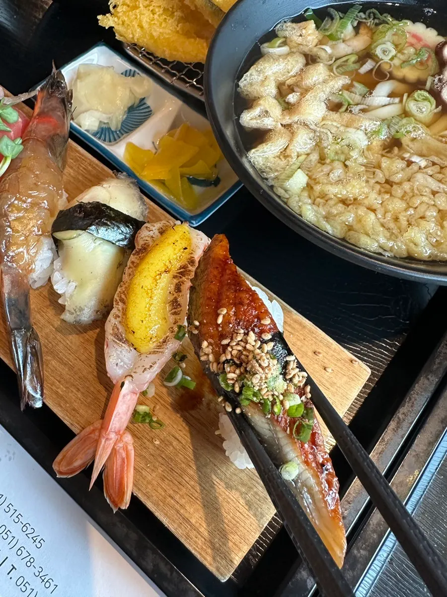 Plate of sushi topped with tuna and raw shrimp