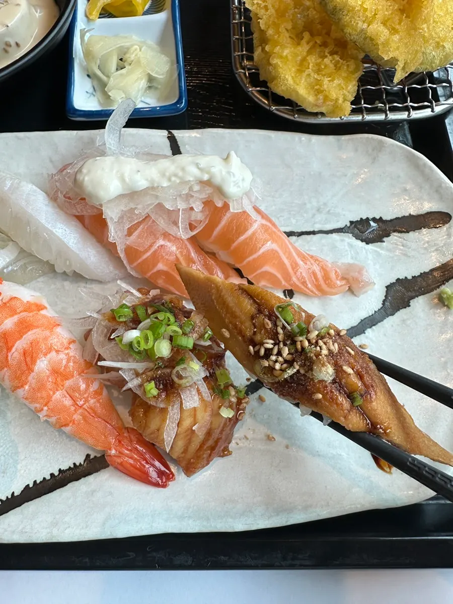 Flounder sushi dipped in wasabi soy sauce