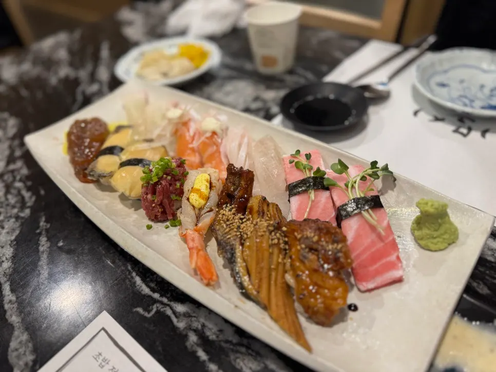 Table spread with 16-piece sushi, seafood yaki udon and chashu