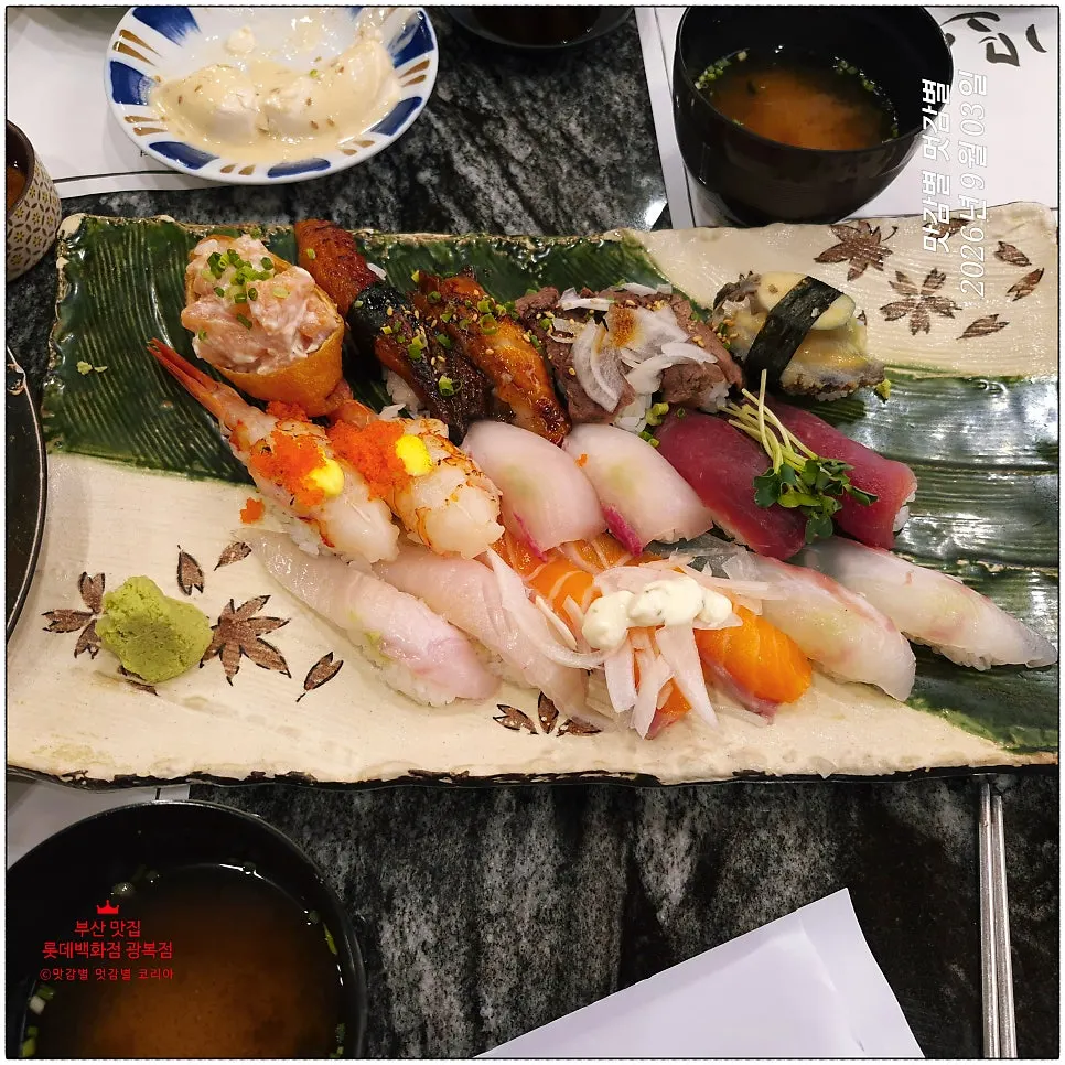 Assorted sushi lined up on a wooden tray