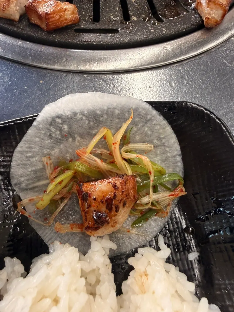 A piece of pork jowl wrapped in perilla leaf