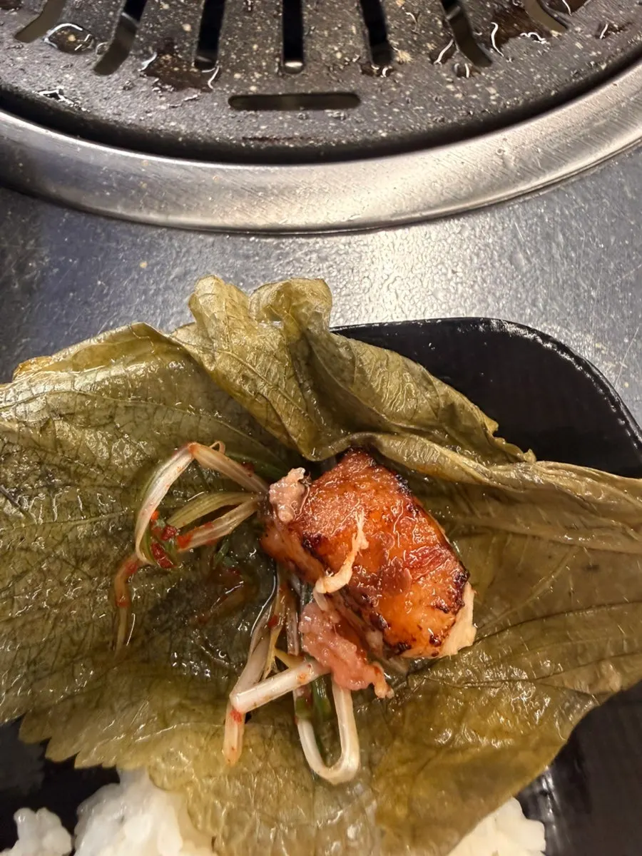 Close-up of pork jowl dipped in sauce