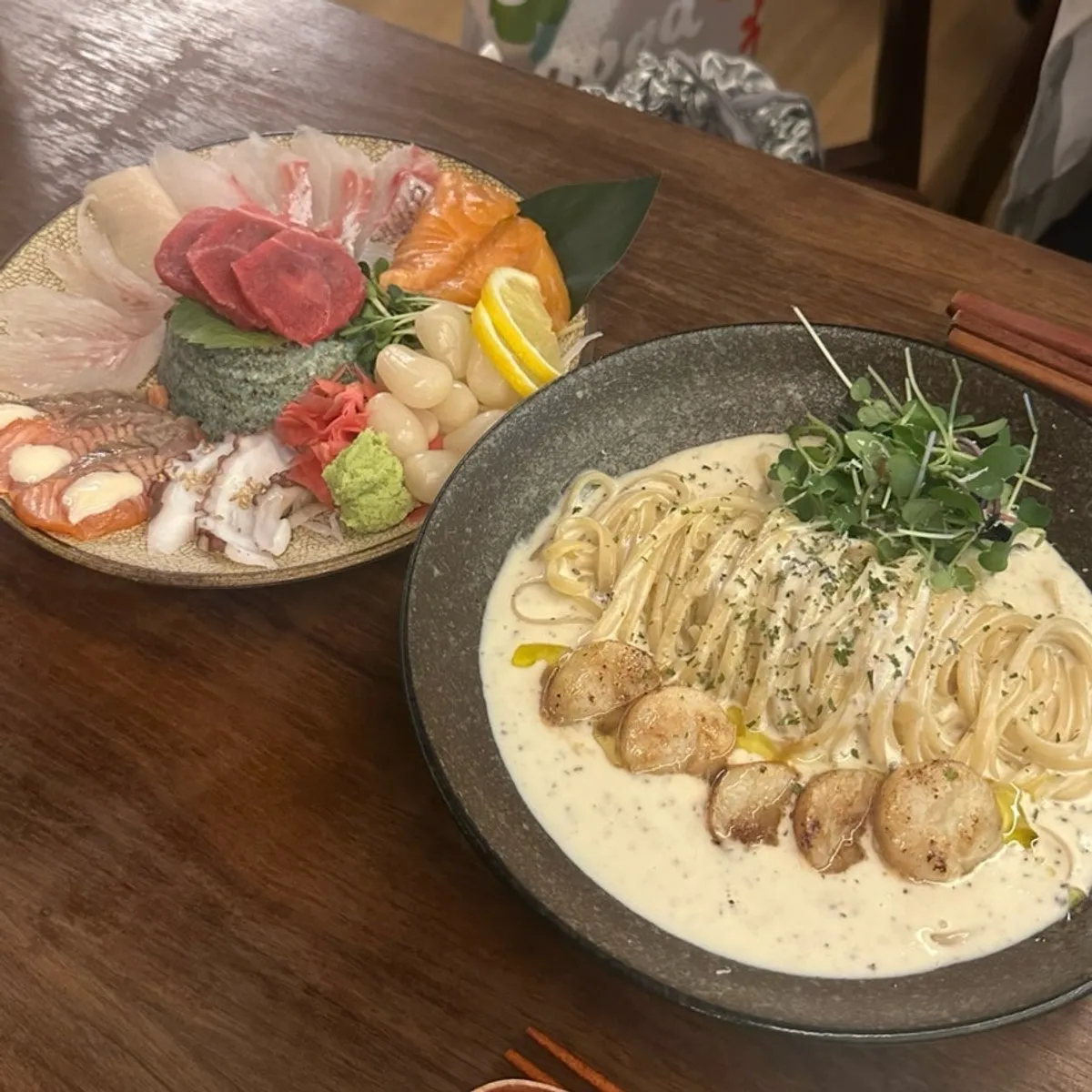 Table at Motokurashi with sashimi and pasta laid out