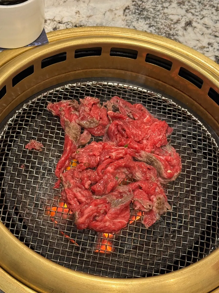 Seasoned hanwoo grilling over charcoal