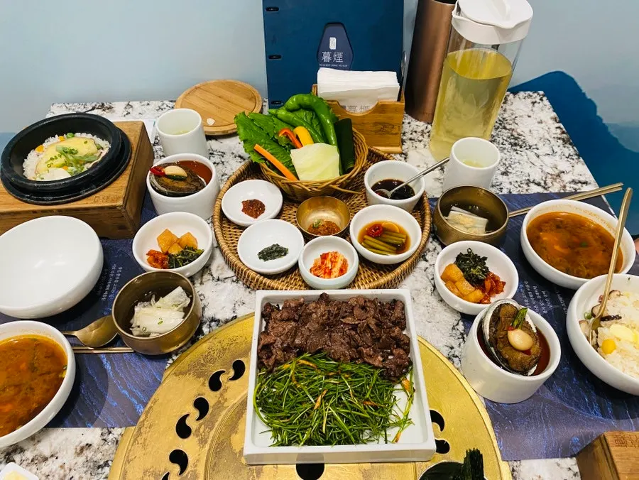 Grilled beef served alongside doenjang jjigae and side dishes