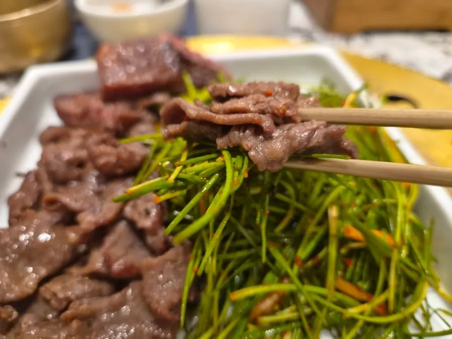 A bite of meat placed over scorched rice crust