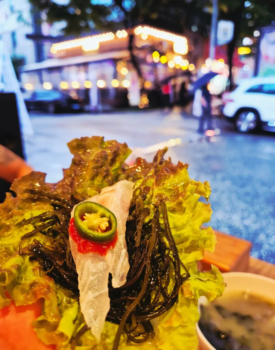 Raw fish wrapped in lettuce and perilla leaves