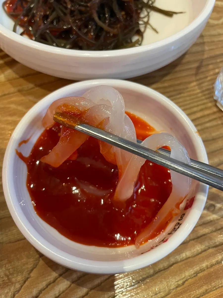 Soju glasses with squid sashimi spread