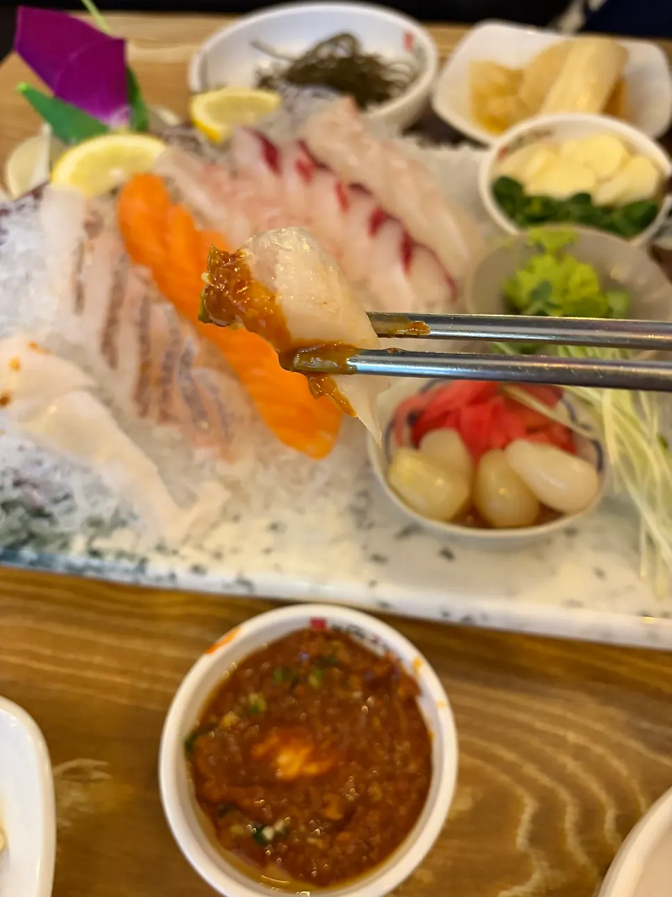 Squid sashimi being picked up with chopsticks