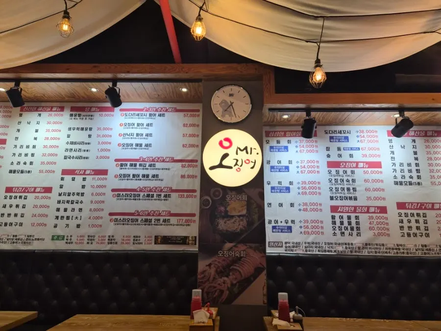Wall menu listing squid sashimi and seafood dishes