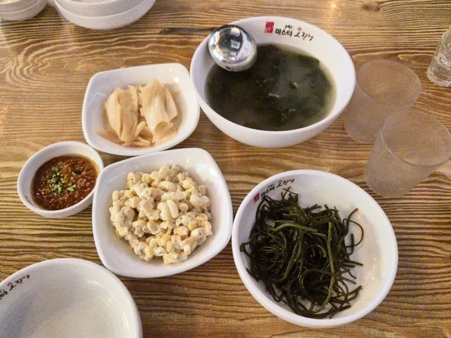 Side dish spread with white kimchi, seaweed salad, and seaweed soup