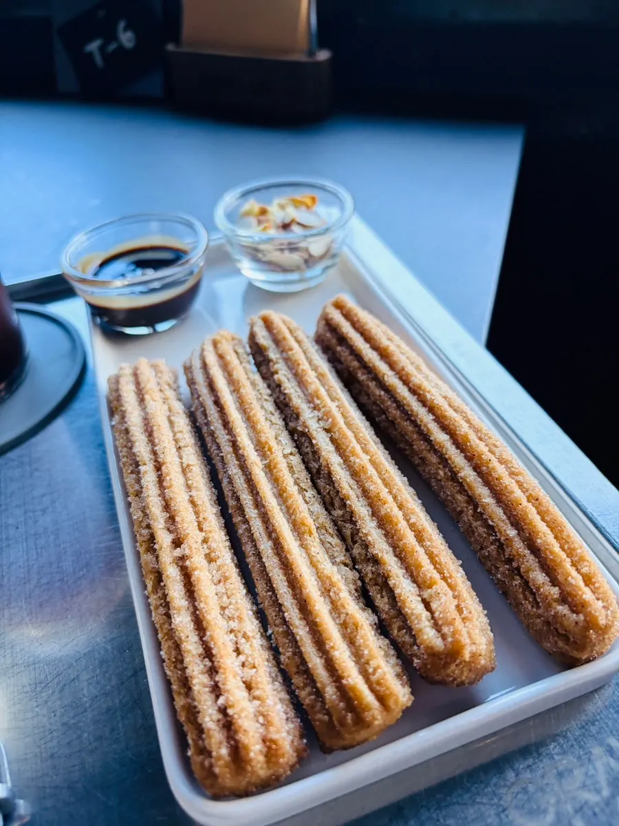 Churros with chocolate sauce and almonds