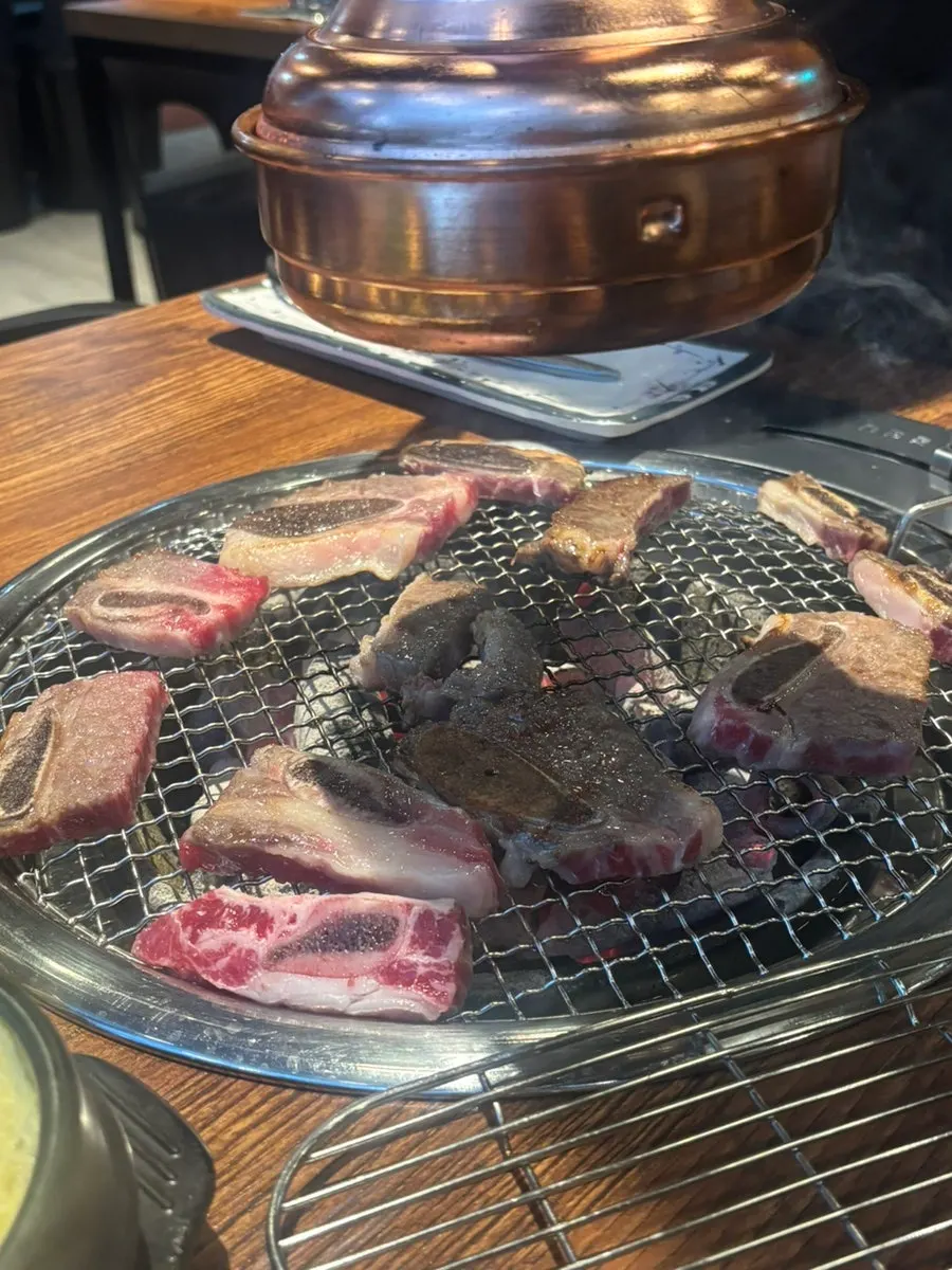 Fresh beef ribs grilling over charcoal