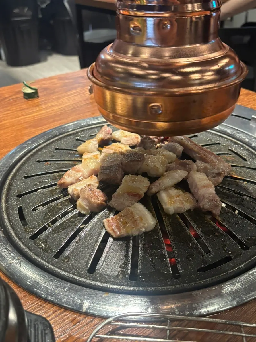 Thick fresh pork ribs grilling over charcoal