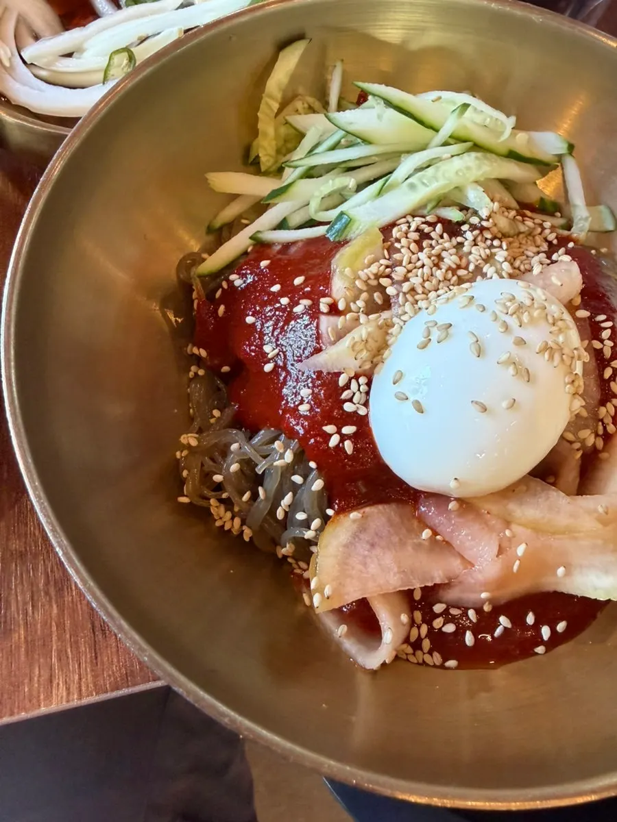 A bowl of bibim naengmyeon tossed with sauce