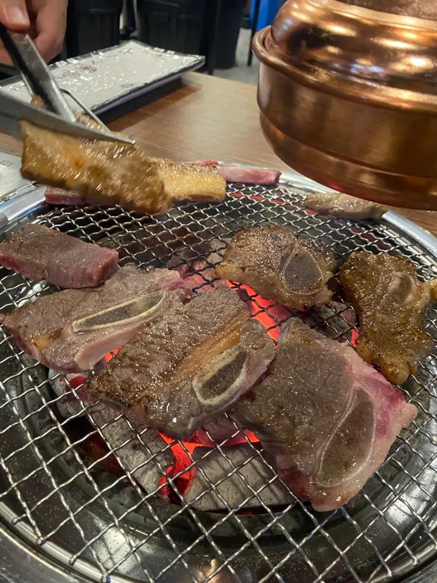 Beef ribs grilling over charcoal