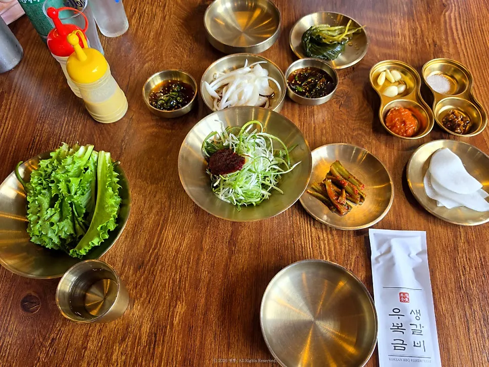 Table of banchan including scallion salad and wild garlic leaves