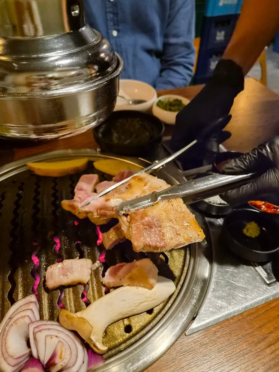 소금과 김치, 소스를 곁들인 삼겹살 한 점