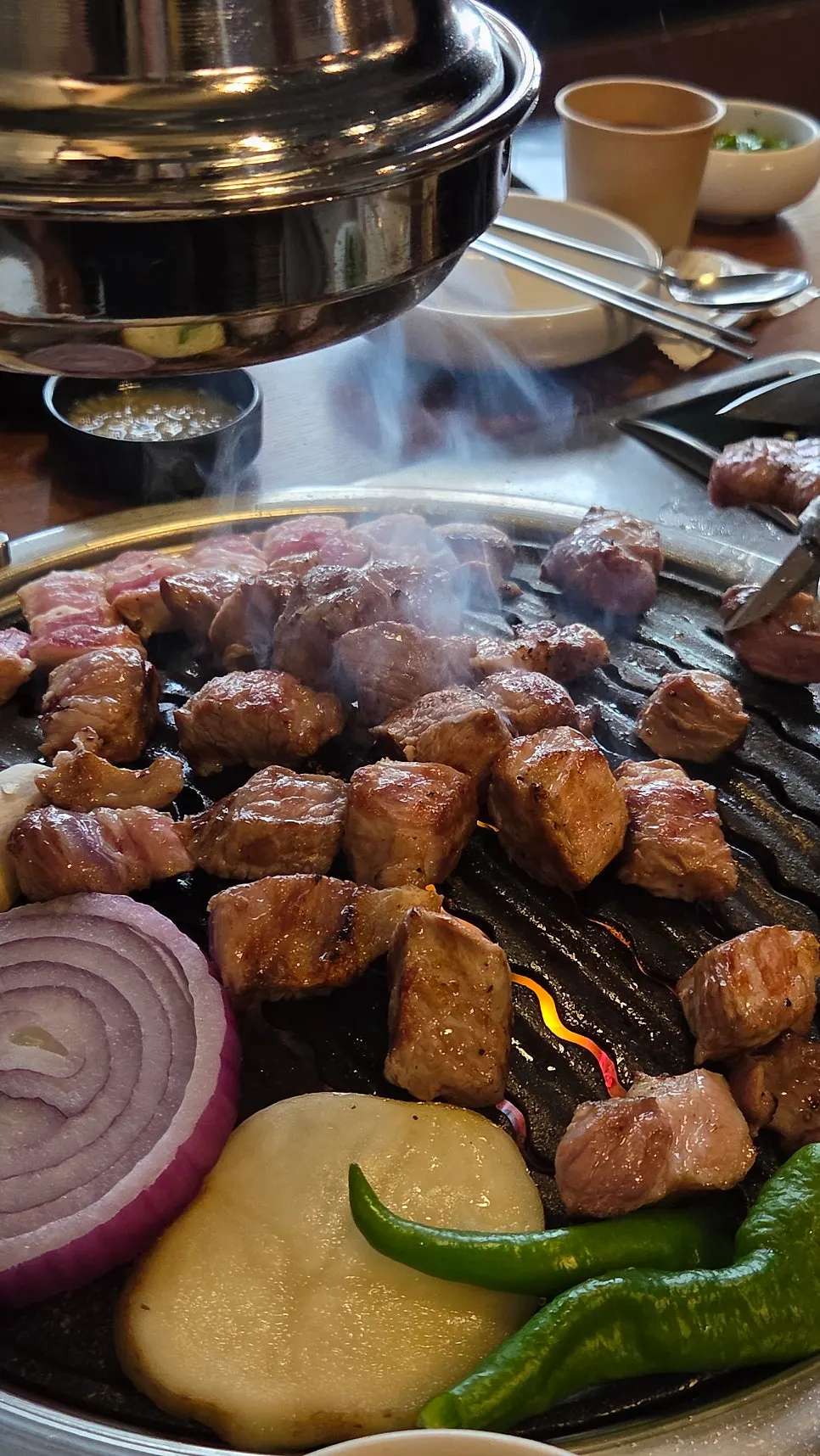 Staff grilling the Hanwoo pork mixed set on the grill plate