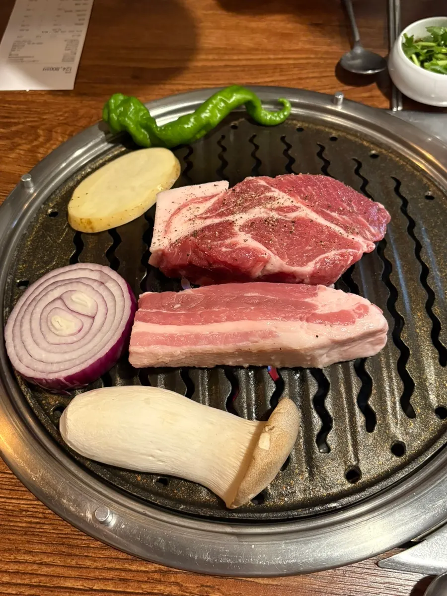 Thick pork neck and pork belly grilling over charcoal