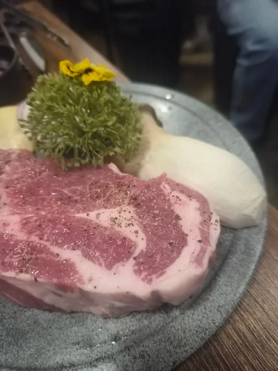 Close-up of raw pork neck dusted with pepper